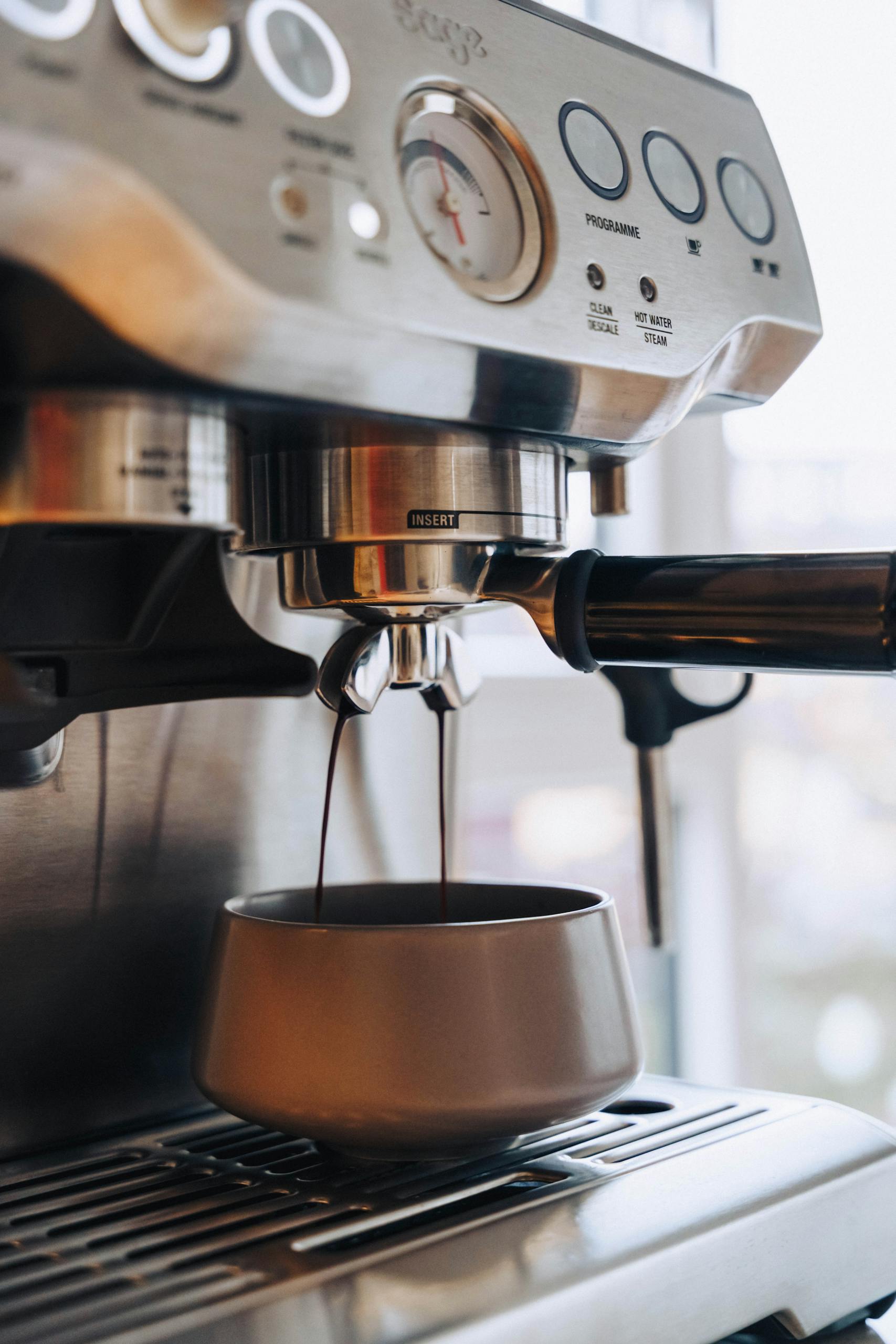 Close-up of an espresso machine brewing fresh coffee into a cup.